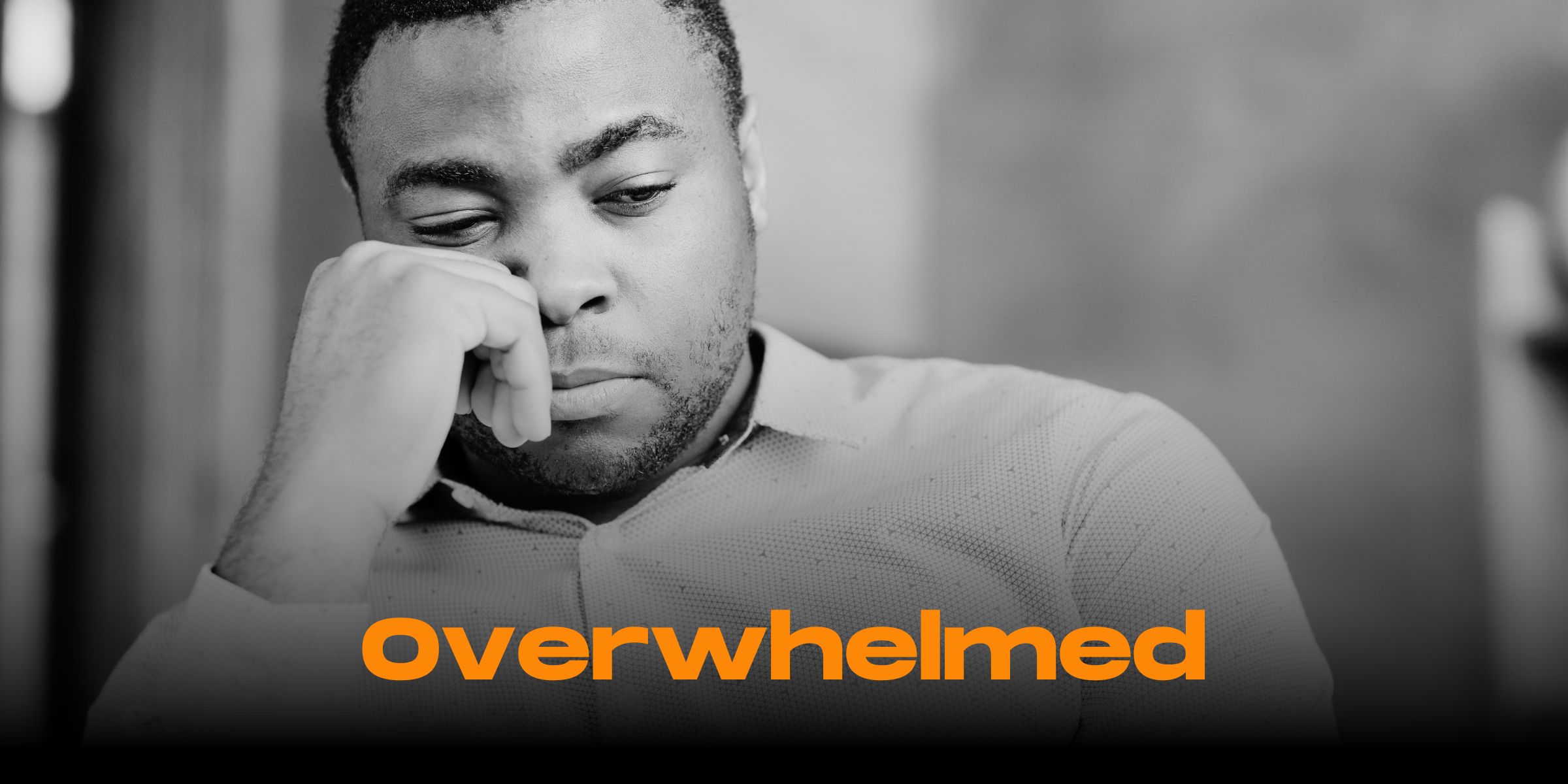 Young black man looking overwhelmed and rubbing his neck